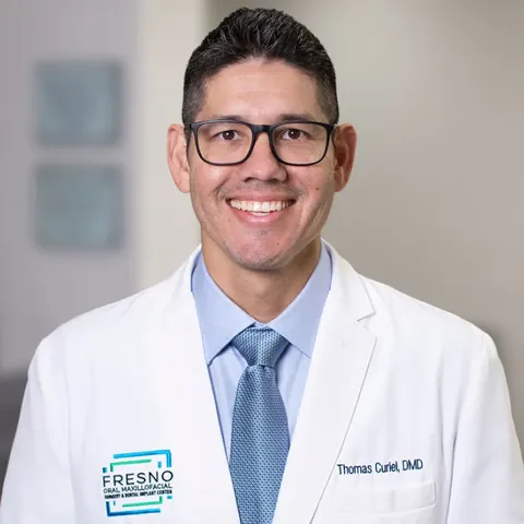 Portrait of Dr. Thomas Curiel, DMD, in a white coat