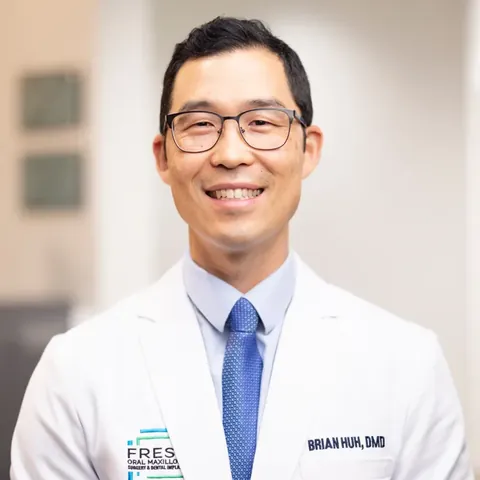 Portrait of Dr. Brian Huh, DMD, in a white coat