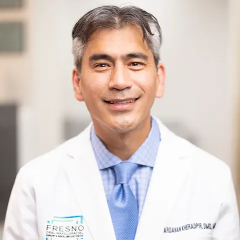 Portrait of Dr. Ardavan Kheradpir, DMD, MD, in a white coat